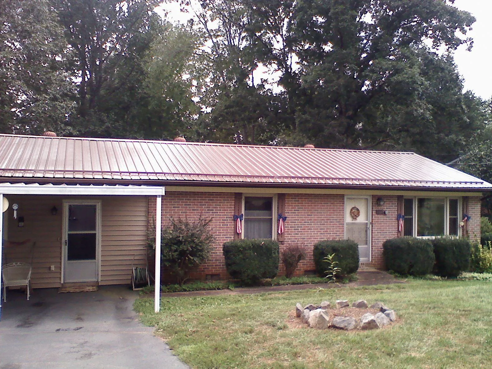 Bronze metal roof and carport on a brick ranch home — Roof Repair work by our crew in Westwood
